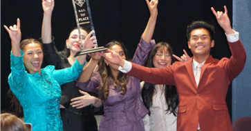 Students celebrating with a trophy.