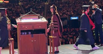 Interm Dean Anita Vangelisti congratulates students as they walk across the stage at Commencement.