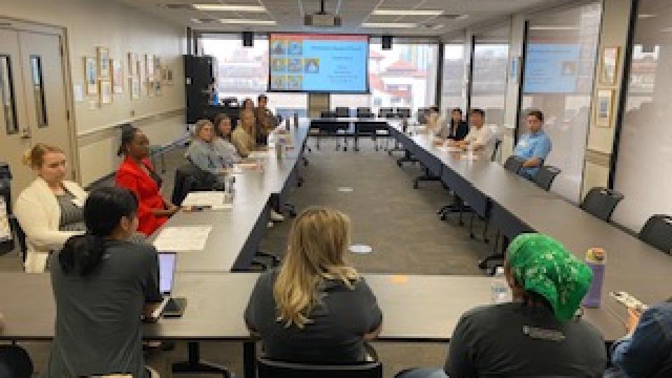 CMS students in classroom discussing lecture slides.