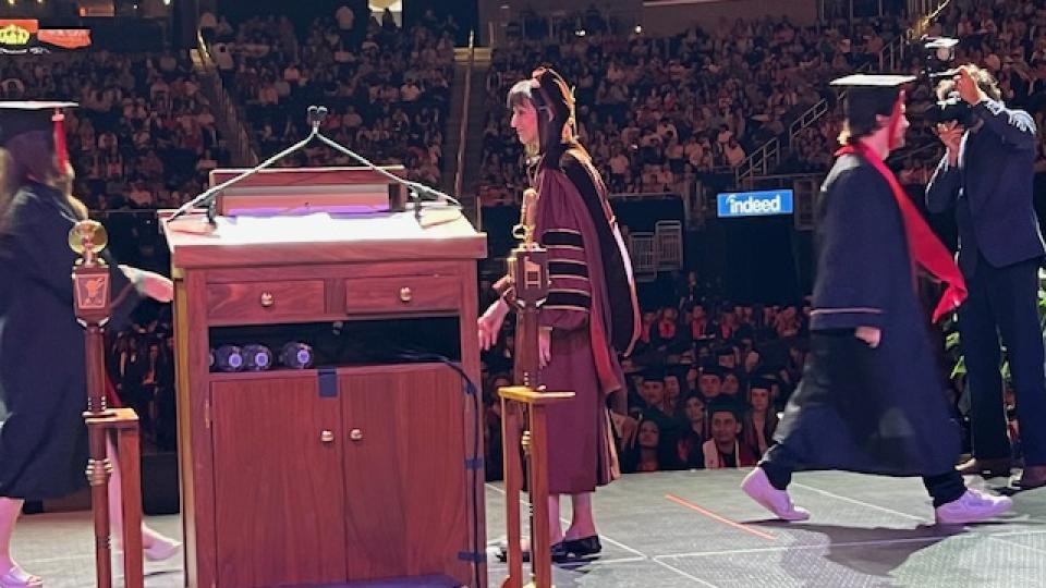 Interm Dean Anita Vangelisti congratulates students as they walk across the stage at Commencement.