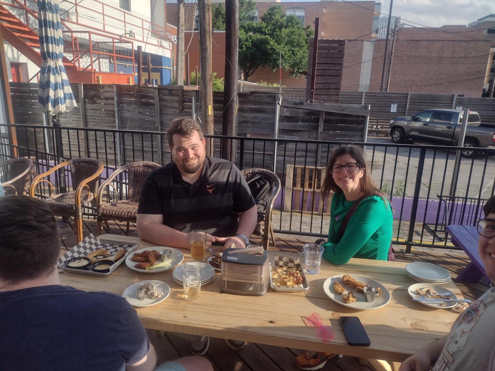 Two CMS Faculty sitting at a table and smiling at the camera.