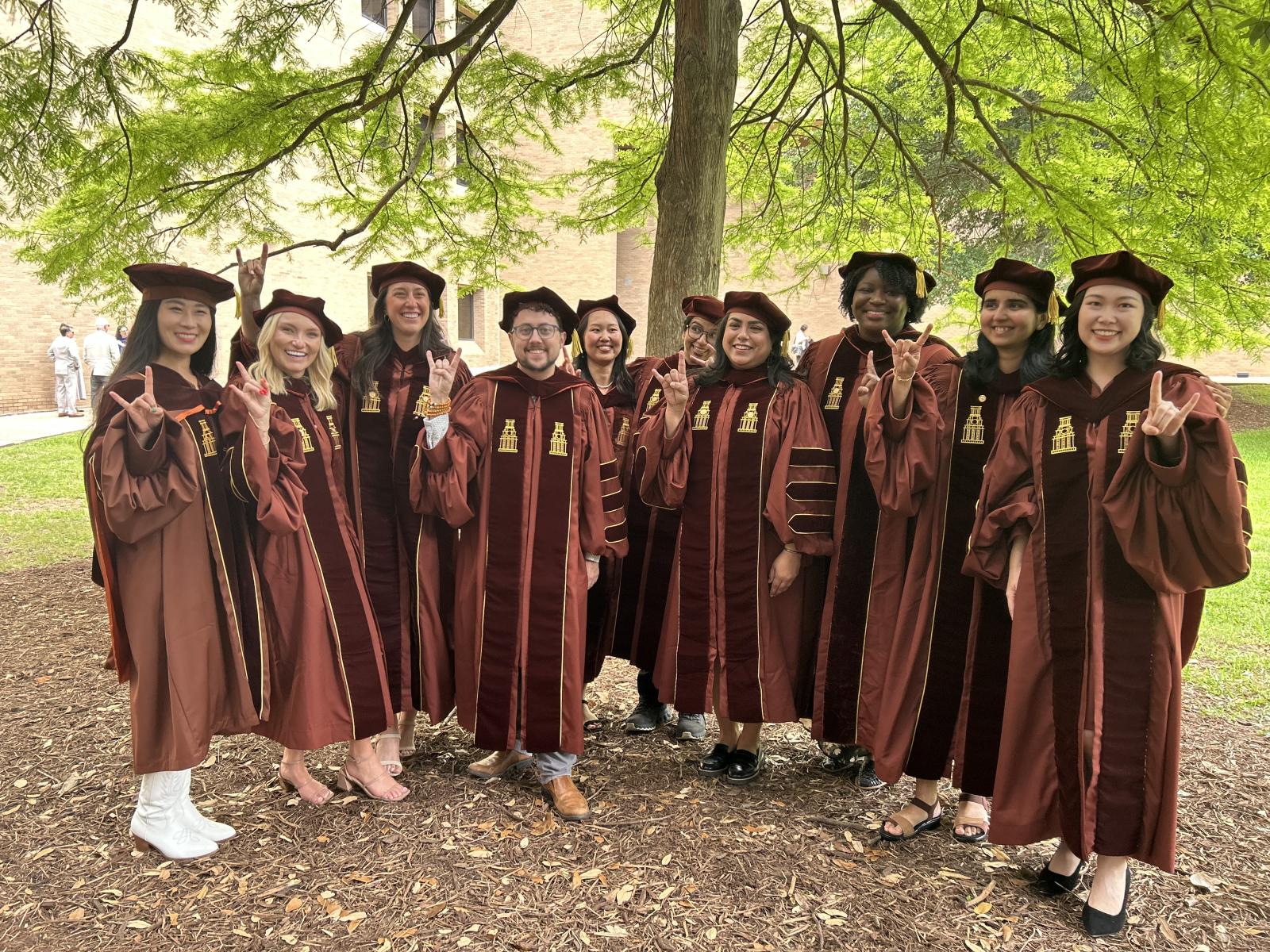 CMS doctoral students in their graduation attire.
