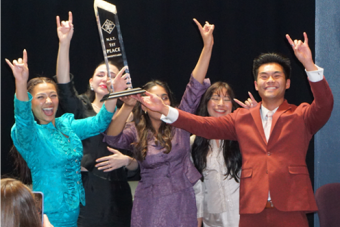 Students celebrating with a trophy.