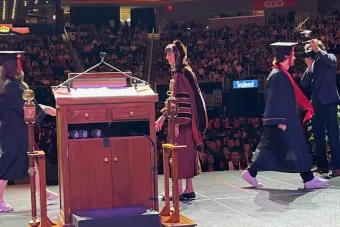 Interm Dean Anita Vangelisti congratulates students as they walk across the stage at Commencement.